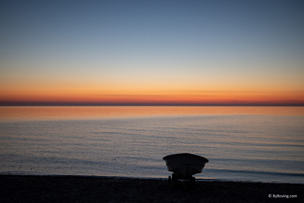 Beautiful sunset with the silhouette of a boat.